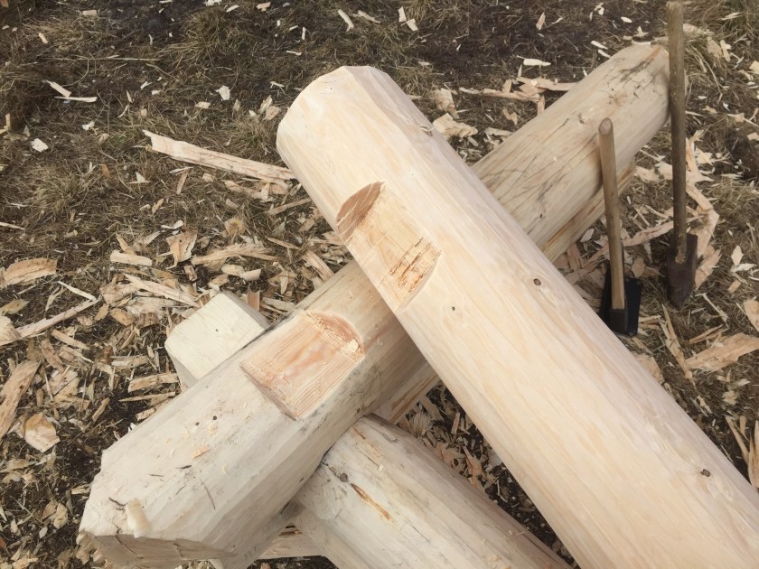 ￼Figur 9. Her er det hugget ut en "liggeflate" i over- og understokken slik at de kan ligge stabilt mot hverandre mens noven på overstokken hugges. Foto: Henrik Jenssen.